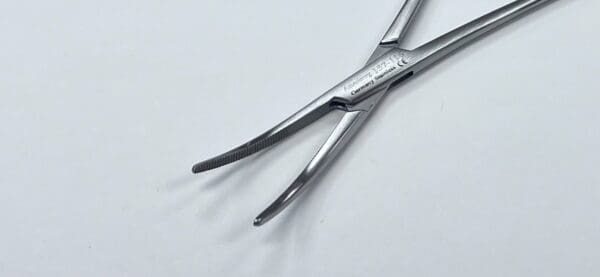 A pair of surgical tweezers on a white surface.