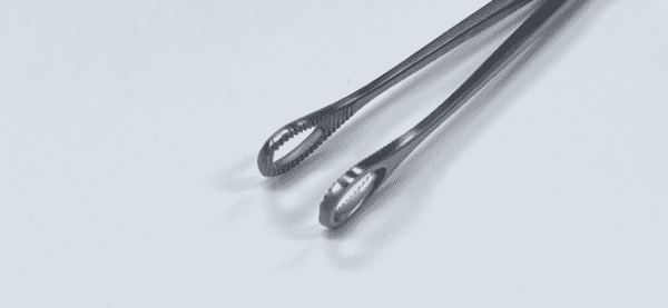 A pair of FOERSTER SPONGE FORCEP tongs on a white surface.