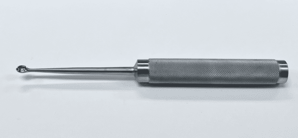 A COBB SPINAL CURETTE with a metal handle on a white surface.