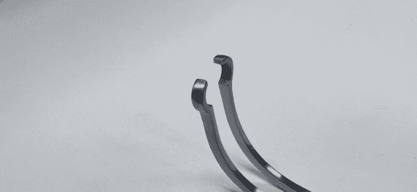 A pair of JAVID CAROTID CLAMP on a white surface.