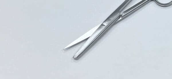 A pair of OPERATING SCISSOR SHARP/BLUNT on a white surface.