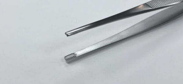 A pair of BROWN TISSUE FORCEP on a white surface.