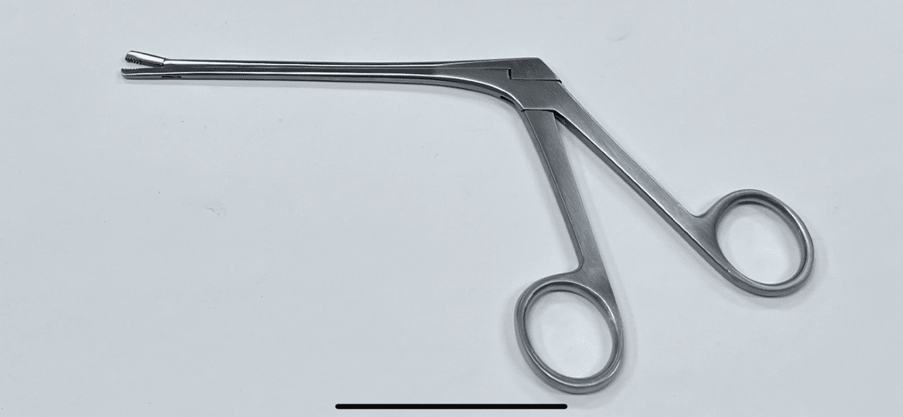A Cartilage Grasper on a white surface.