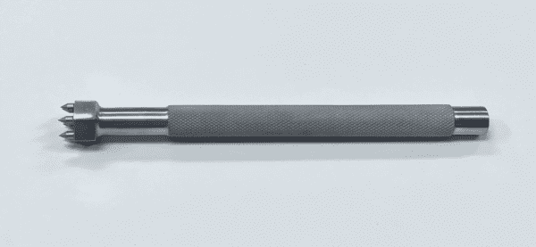 A stainless steel TIBIA PUNCH, WOOLLEY TYPE on a white surface.