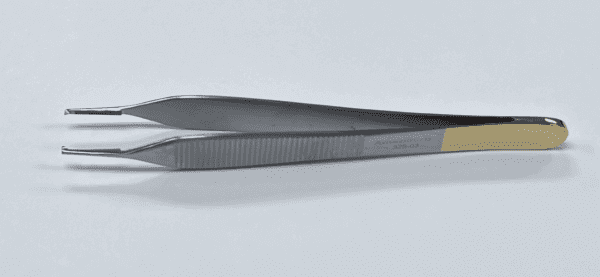 A pair of TC ADSON TISSUE FORCEP on a white surface.