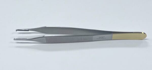 A pair of TC ADSON TISSUE FORCEP on a white surface.
