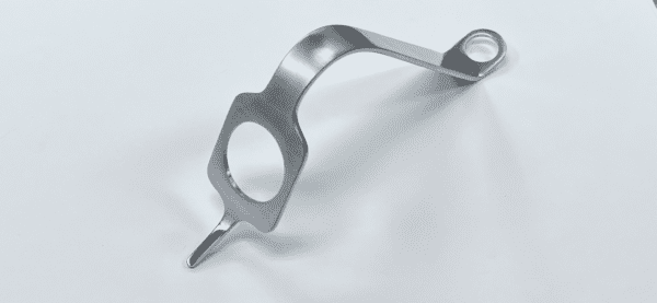 A MIS KNEE PATELLAR RETRACTOR with a hole in it on a white surface.