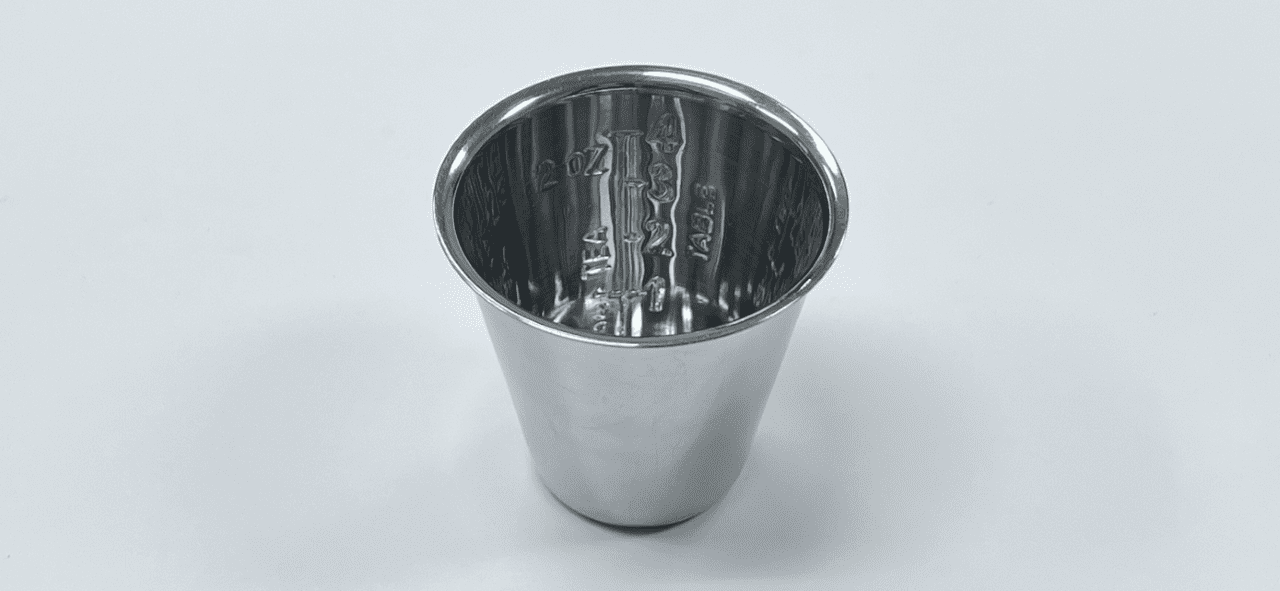 A MEDICINE CUP on a white surface.