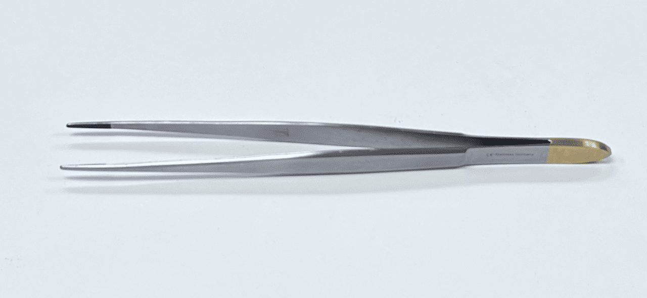 A pair of TC CUSHING TISSUE FORCEP tweezers on a white surface.