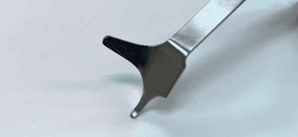 A POSTERIOR-INFERIOR RETRACTOR on a white surface.