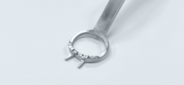 A Glenoid Access Retractor is sitting on a white surface.