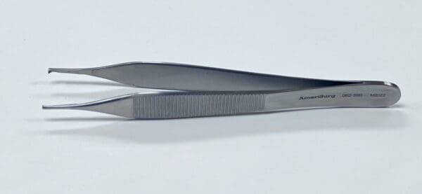 A pair of CALLISON ADSON TISSUE AND TYING FORCEPs on a white surface.