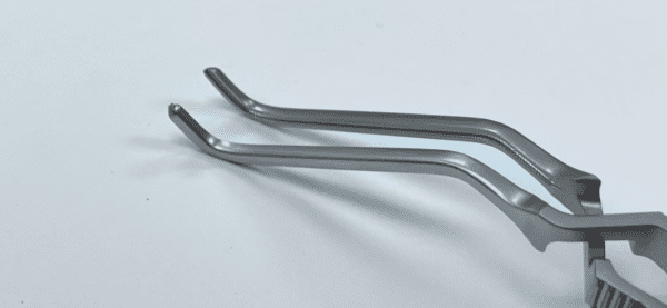 A pair of GREGORY CAROTID ANGLED BULLDOG CLAMP tweezers on a white surface.