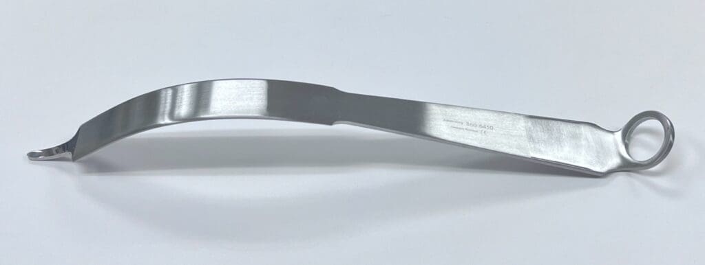 A SOFT TISSUE RETRACTOR, SINGLE PRONG handle on a white surface.
