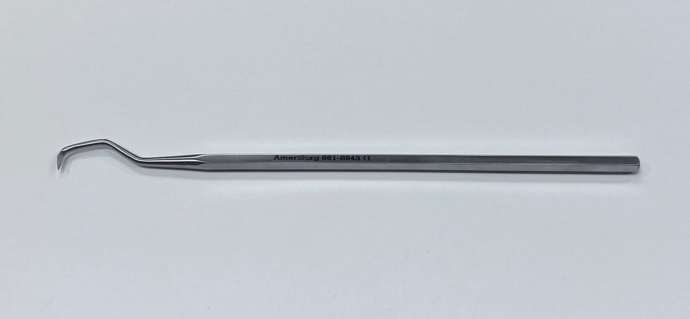 An ORTHOPEDIC PICK/SCRAPER with a long handle on a white surface.