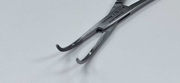 A pair of ADSON-BABY HEMOSTATIC FORCEP on a white surface.