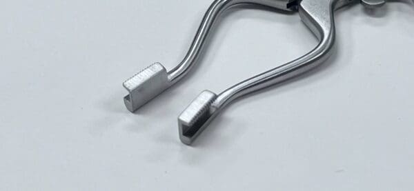 A pair of BURGESS TYPE CARPAL TUNNEL RETRACTOR on a white surface.