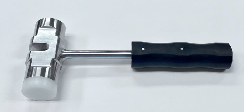 A Slotted Mallet with a black handle on a white surface.