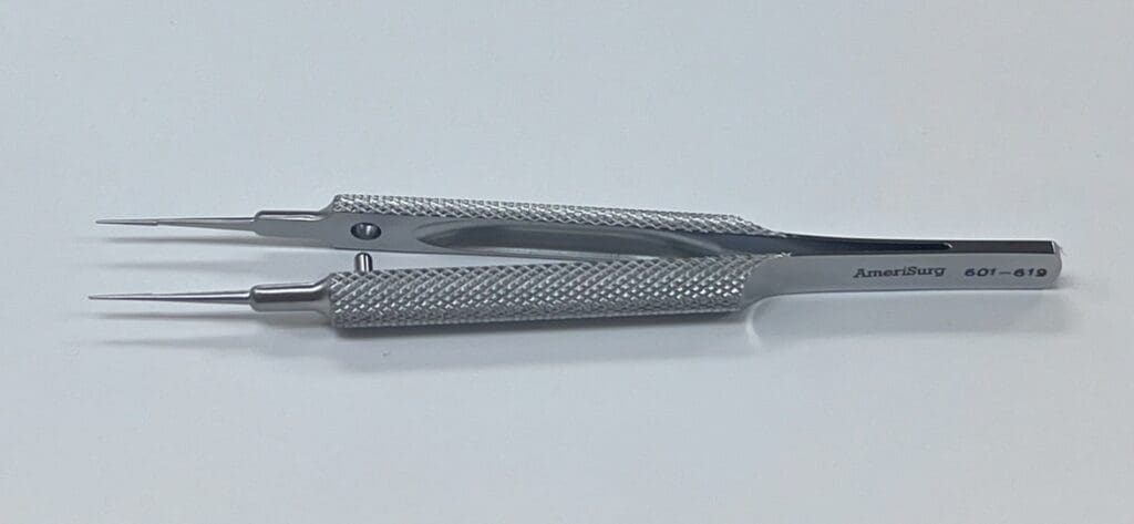 A pair of TENNANT TYING FORCEP on a white surface.