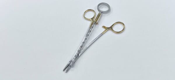 A pair of surgical scissors on a white surface.