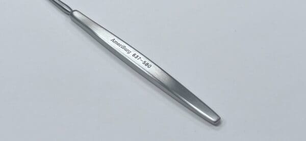 A silver SICKLE KNIFE with writing on it.